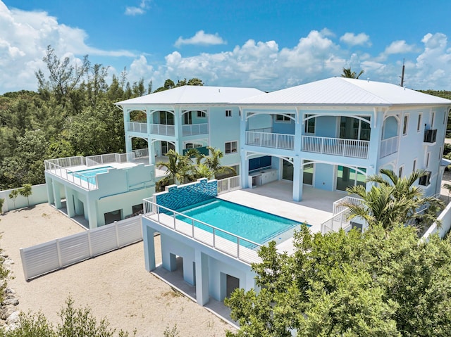 back of property with a fenced in pool and a patio area