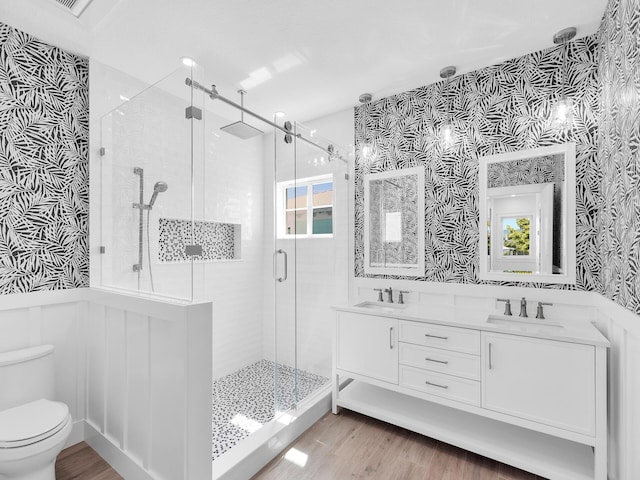 bathroom featuring vanity, wood-type flooring, toilet, and walk in shower