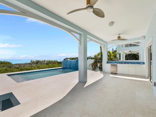 view of pool featuring a patio area, pool water feature, ceiling fan, and a water view