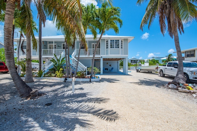 306 N Anglers Dr Unit B, Marathon, FL 33050 - view of front of home featuring a carport, covered porch, stairs, and dirt driveway