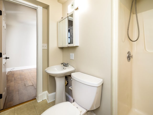 bathroom featuring tile patterned flooring, walk in shower, and toilet