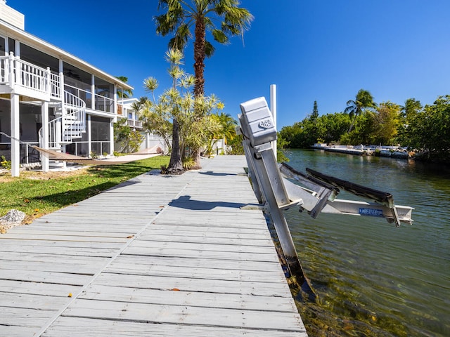 dock area with a water view and a yard