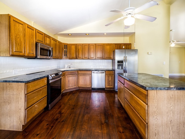 kitchen featuring lofted ceiling, dark hardwood / wood-style flooring, ceiling fan, stainless steel appliances, and decorative backsplash