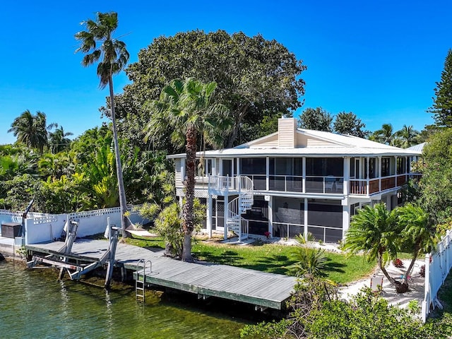 rear view of house featuring a sunroom and a water view