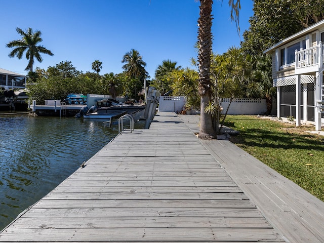 view of dock featuring a water view and a lawn