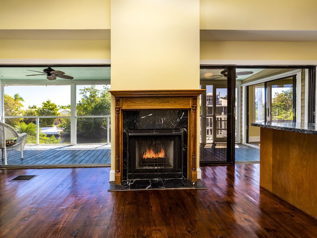 unfurnished living room featuring dark hardwood / wood-style floors, a high end fireplace, and ceiling fan