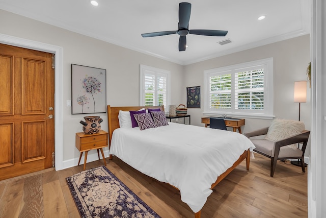 bedroom with ornamental molding, multiple windows, and light hardwood / wood-style flooring