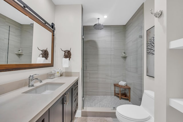 bathroom with an enclosed shower, vanity, and toilet