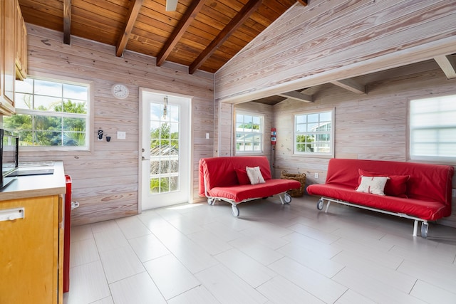 living area with wooden walls, wooden ceiling, and lofted ceiling with beams