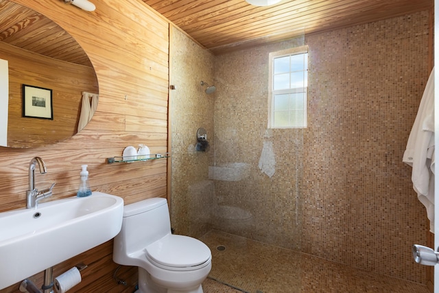 bathroom featuring a tile shower, sink, wood ceiling, and toilet