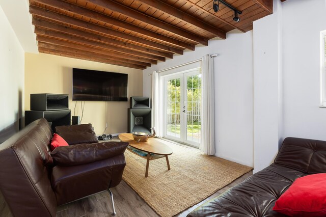 living room with beam ceiling, wood-type flooring, and wooden ceiling