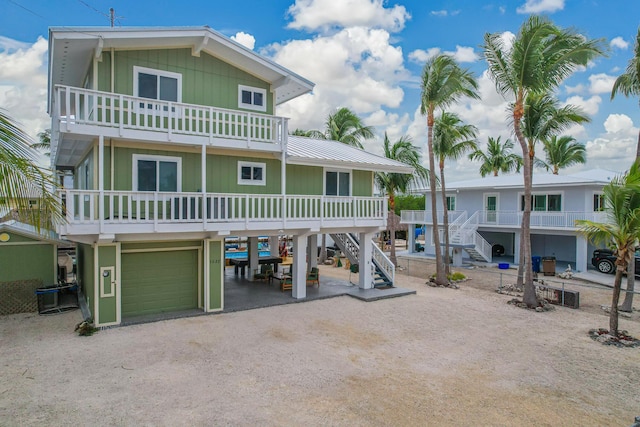 coastal home featuring stairs, a carport, a garage, and driveway