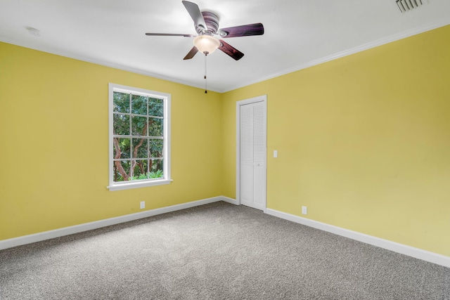 carpeted spare room with ornamental molding and ceiling fan