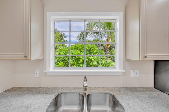 kitchen featuring a healthy amount of sunlight, sink, and white cabinets