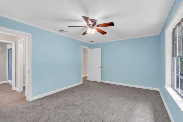 carpeted spare room featuring crown molding and ceiling fan