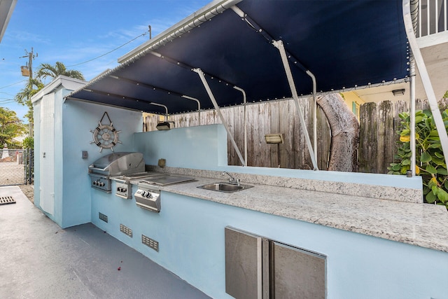 view of patio / terrace featuring area for grilling, sink, and a grill