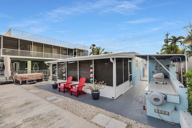 back of house featuring a hot tub and a sunroom