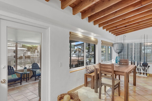 dining space with beamed ceiling and light tile patterned floors