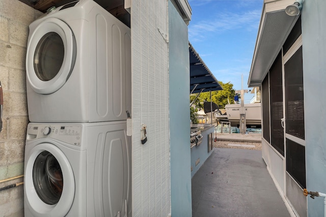 clothes washing area with stacked washer and clothes dryer