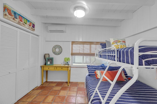 bedroom featuring beamed ceiling, a closet, a wall unit AC, and wooden ceiling