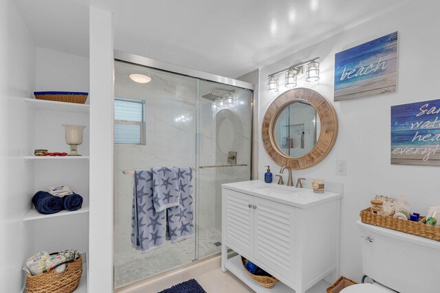 bathroom with vanity, toilet, and a shower with shower door