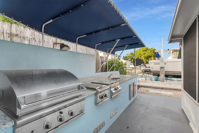 view of patio / terrace with an outdoor kitchen, sink, and area for grilling