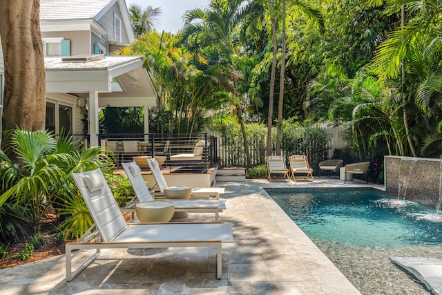 view of swimming pool with pool water feature and a patio area