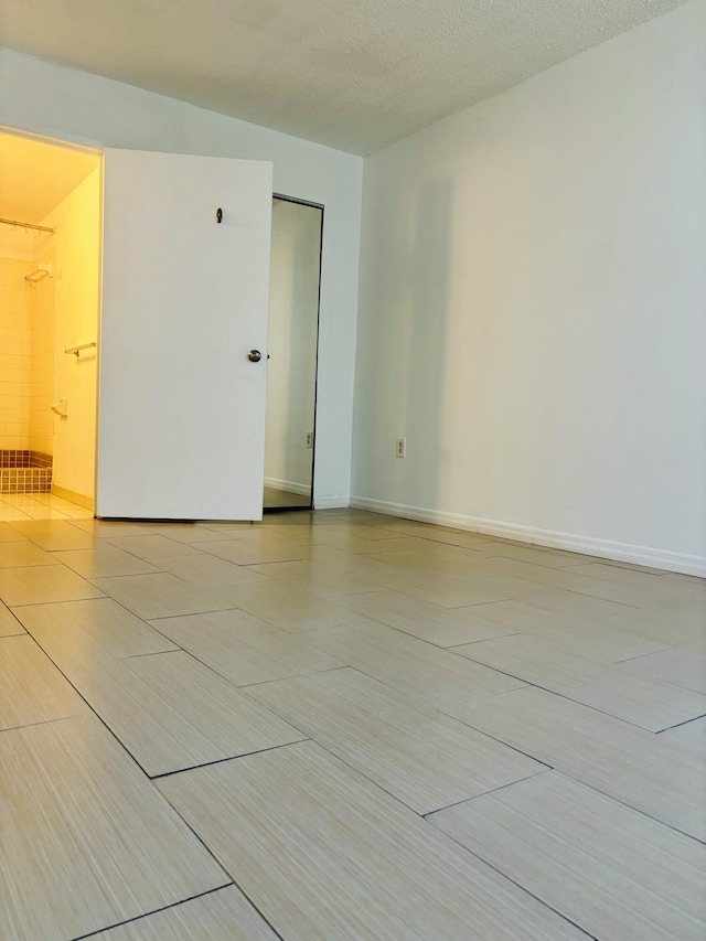 unfurnished room with a textured ceiling