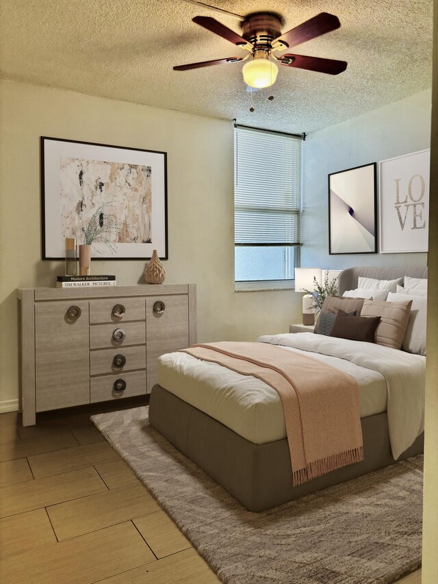 bedroom with ceiling fan, hardwood / wood-style floors, and a textured ceiling