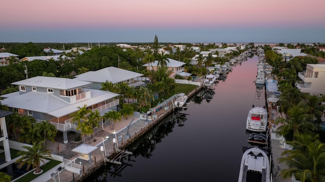 aerial view at dusk featuring a water view