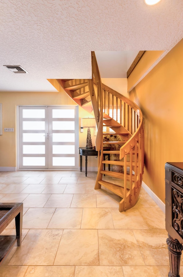 stairs with beamed ceiling and a textured ceiling