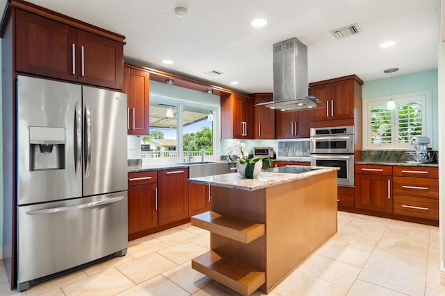 kitchen featuring a kitchen island, decorative light fixtures, island exhaust hood, light stone counters, and stainless steel appliances