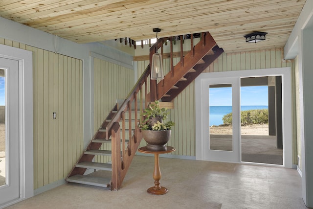 staircase with a water view and wooden ceiling