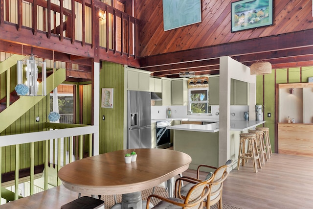 dining space featuring light hardwood / wood-style floors and beamed ceiling