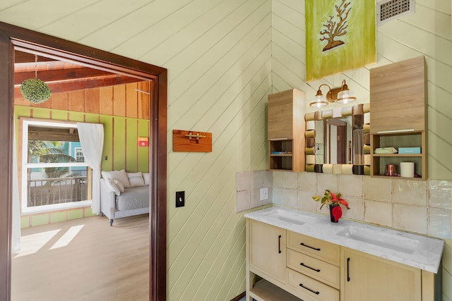 bathroom featuring tasteful backsplash, lofted ceiling, vanity, and hardwood / wood-style flooring