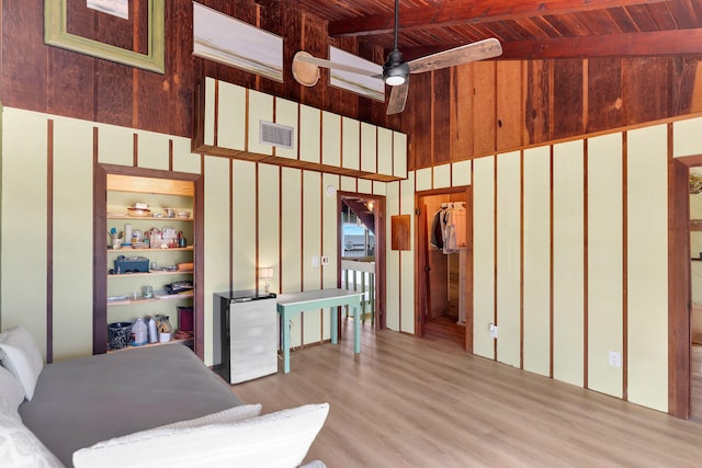 interior space with wood ceiling, ceiling fan, and wood walls