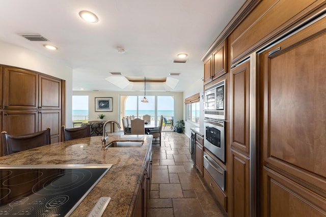 228 W Seaview Cir, Duck, FL 33050 - kitchen featuring a sink, stainless steel appliances, stone tile floors, a warming drawer, and healthy amount of natural light