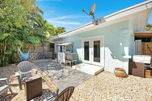 back of house with french doors, fence, a patio, and stucco siding