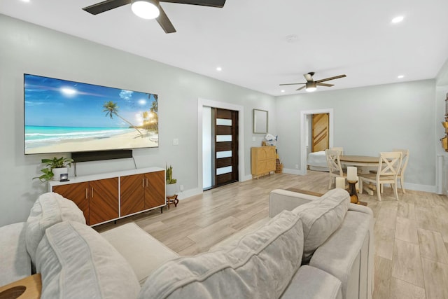 living room with light wood-style flooring, baseboards, ceiling fan, and recessed lighting