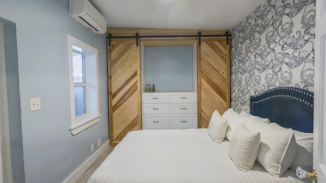 bedroom with baseboards, a barn door, a wall mounted air conditioner, and wooden walls