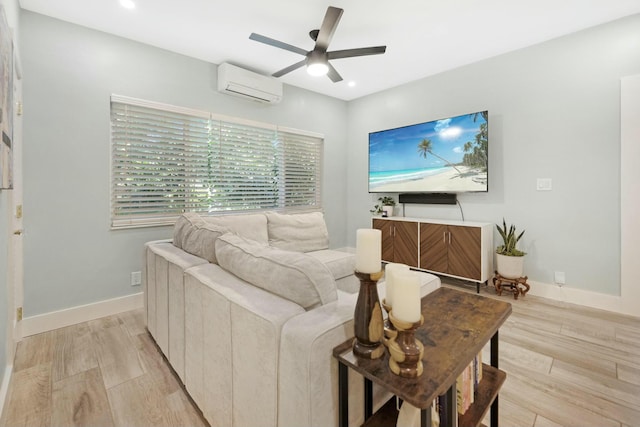 living room with a wall unit AC, recessed lighting, light wood-style floors, a ceiling fan, and baseboards