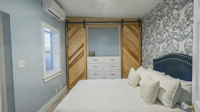 bedroom with wood walls, a barn door, baseboards, and an AC wall unit