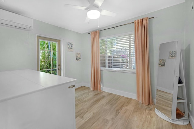 interior space with light wood-style floors, multiple windows, baseboards, and a wall mounted AC