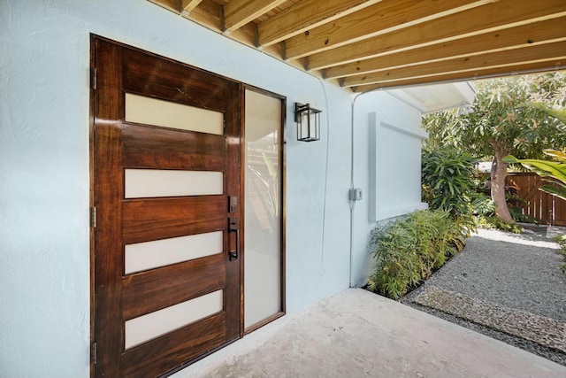 doorway to property featuring stucco siding