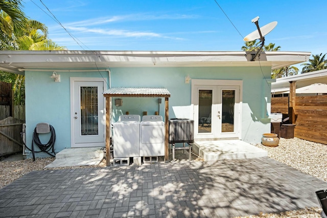 rear view of house with a patio, fence, french doors, separate washer and dryer, and stucco siding