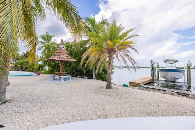 exterior space featuring a gazebo, a boat dock, and a water view