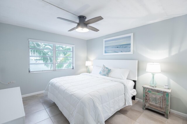 tiled bedroom featuring ceiling fan