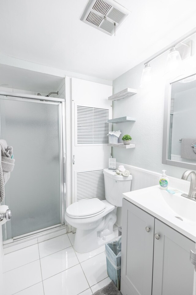 bathroom featuring vanity, an enclosed shower, and toilet