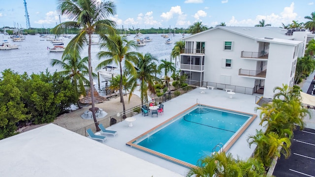 view of pool with a patio and a water view