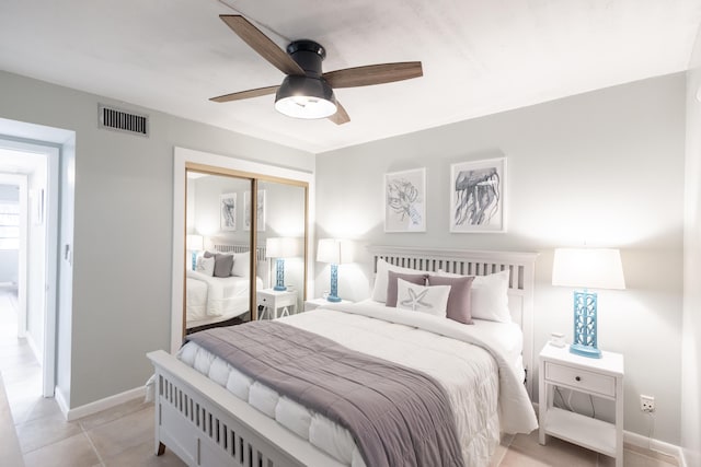 bedroom featuring light tile patterned flooring, ceiling fan, and a closet